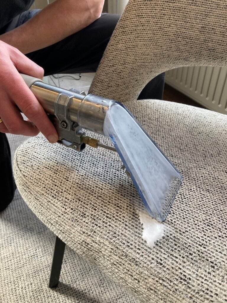 Specialist reinigt meubels met professionele sproei-extractie