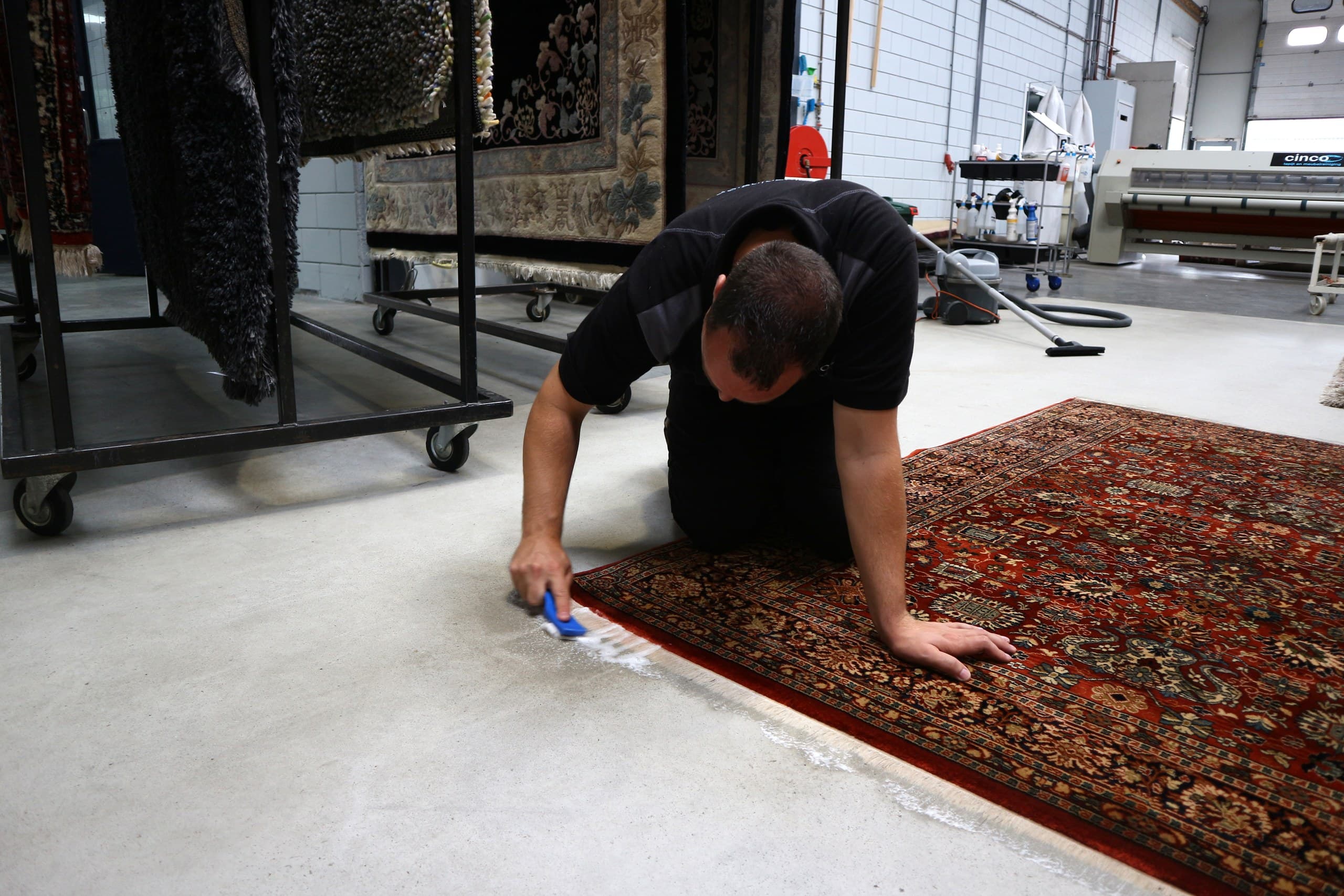 Specialist borstelt met de hand de franje van een Perzisch vloerkleed
