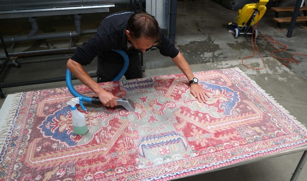 Personeel reinigt het tapijt op een tafel