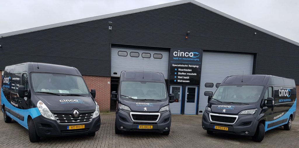 Werkplaats met de bedrijfsbussen van Cinco Cleaning op de achtergrond