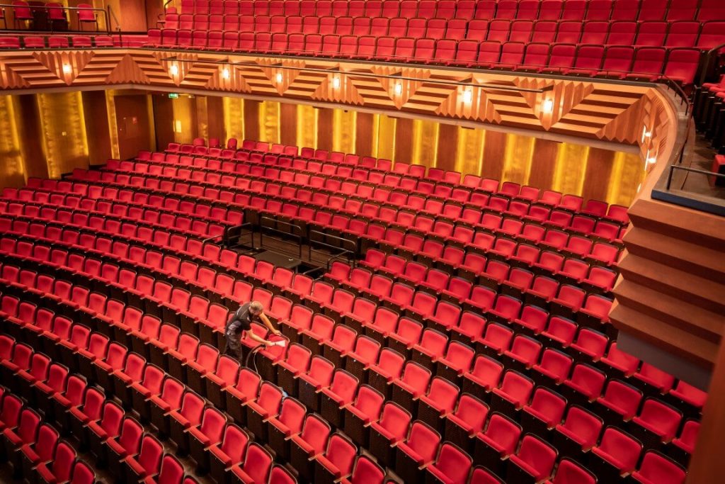 Specialist reinigt de theaterstoelen