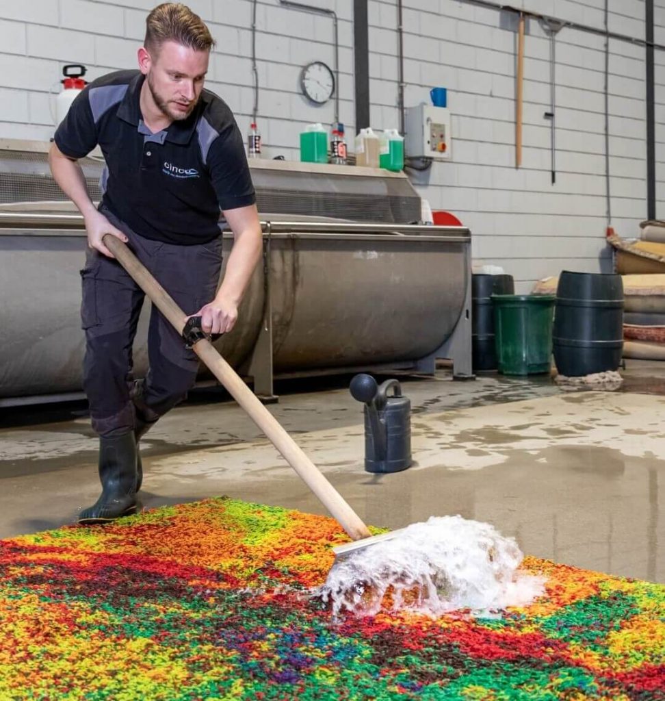 Specialist schrobt en maakt het vloerkleed schoon